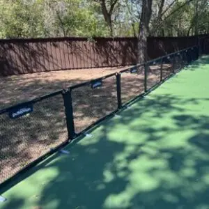 Pickleball court bordered by low chain-link fence