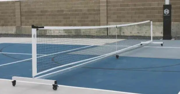 Portable pickleball net on blue court