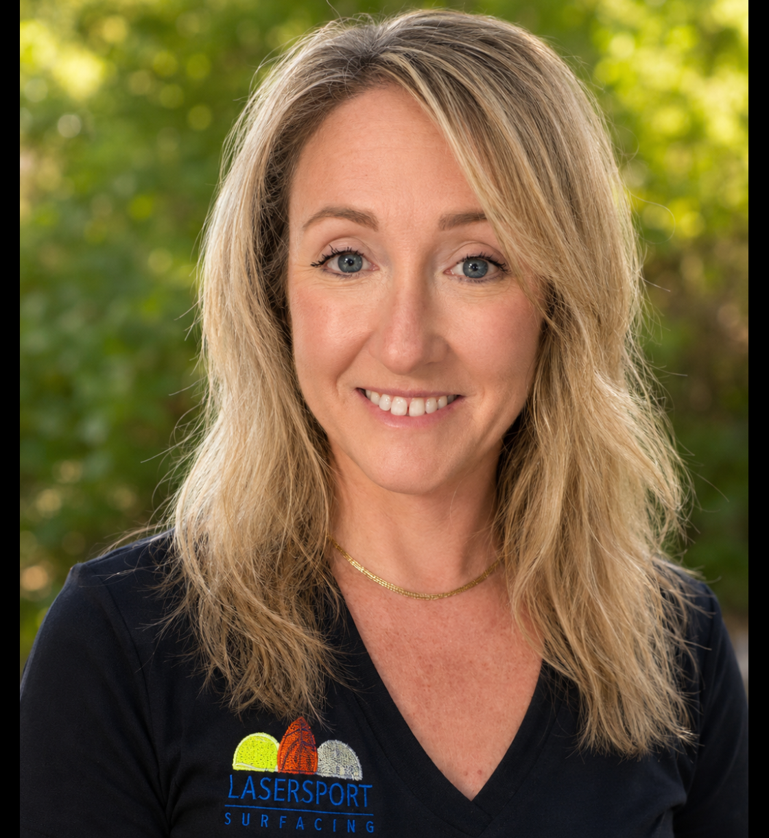 Smiling blonde woman in company shirt outdoors
