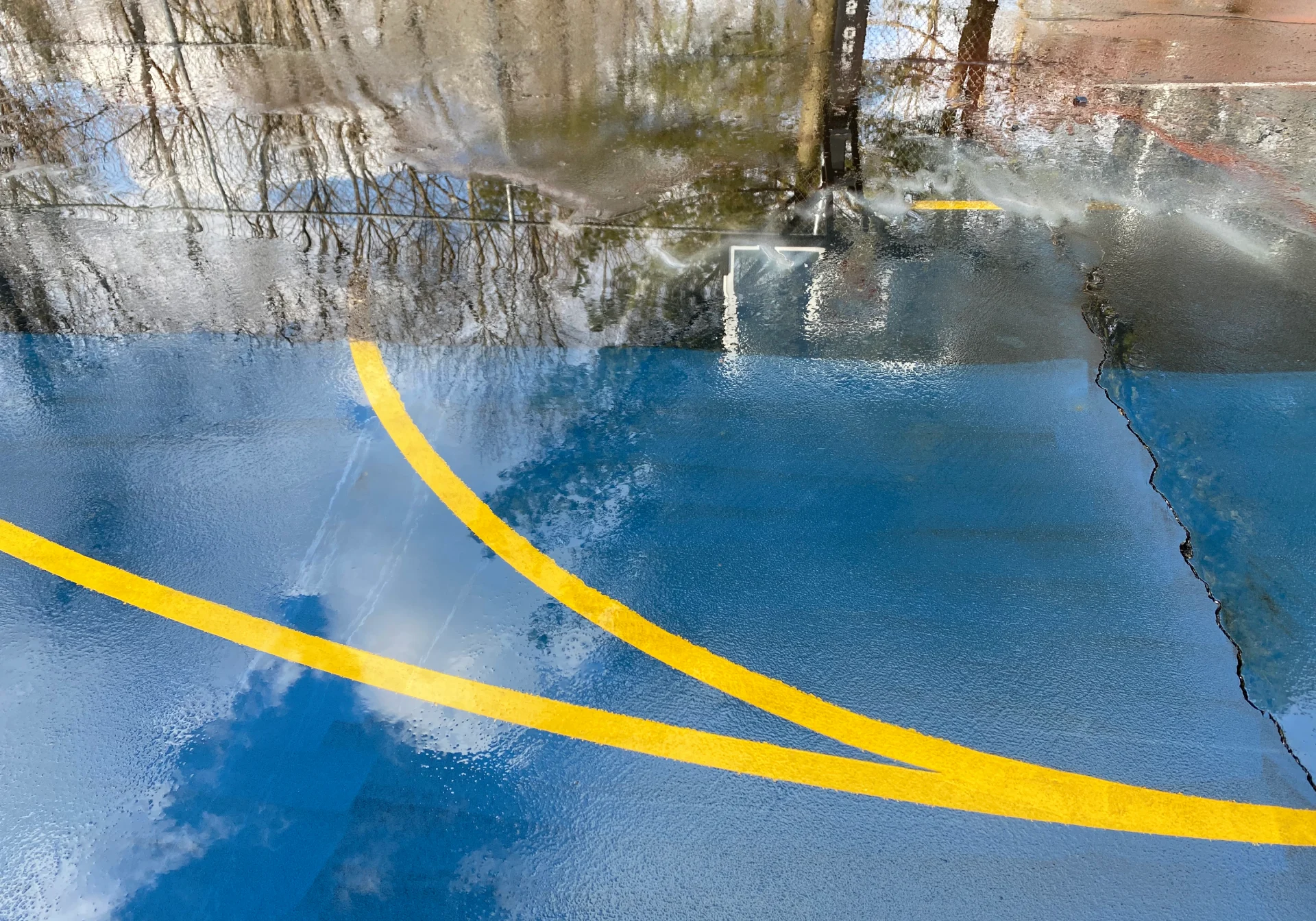 Wet blue basketball court with yellow lines